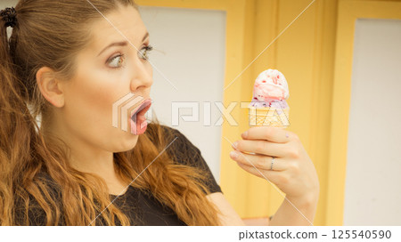 Shocked woman looking at ice cream 125540590
