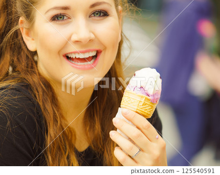 Young woman eating ice cream 125540591