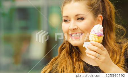 Young woman eating ice cream 125540592
