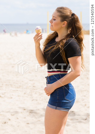 Young woman eating ice cream Young woman eating ice cream 125540594