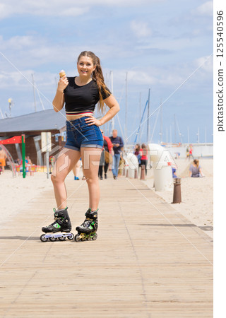 Roller skate woman eating ice cream 125540596