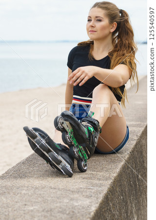 Girl wearing roller skates on seaside 125540597