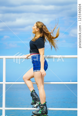 Girl wearing roller skates on seaside 125540604
