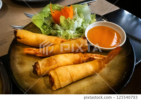 Khung phom pha, prawn tail rolls in a rice wrapper, a dish at a Thai restaurant Khung phom pha, prawn tail rolls in a rice wrapper, a dish at a Thai restaurant 125540783