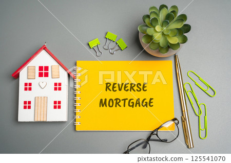 Reverse mortgage concept. Type of loan available to homeowners aged 62 or older, allowing them to convert part of the equity in their home into cash. Business and finance. Notes, inscription, house 125541070
