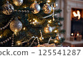 Decorated christmas tree silver gold ornaments glowing lights warm fireplace background cozy home interior festive holiday season family atmosphere peace 125541287