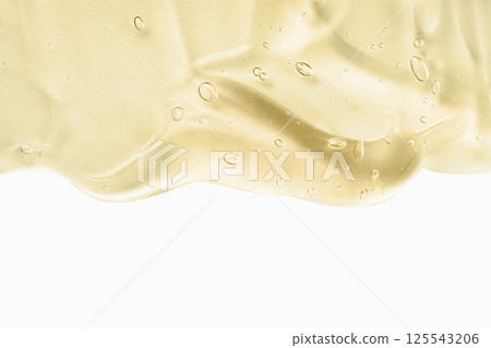 Cosmetic cream transparent liquid gel. Yellow gel smudge isolated on white background. Skincare lotion face serum swatch. Body care. Hyaluron acid for skin care 125543206