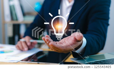 Innovation through ideas and inspiration ideas, Idea of creativity and inspiration concept of sustainable business development, Human hand holding light bulb to illuminate, Creative solutions. Innovation through ideas and inspiration ideas, Idea of creativity and inspiration concept of sustainable business development, Human hand holding light bulb to illuminate, Creative solutions. 125543405