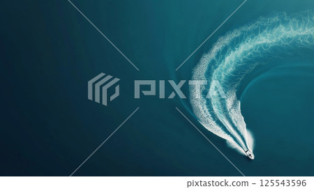 Aerial view of a speedboat creating a large curved wake on a beautiful turquoise water surface, offering a captivating view of motion and fluidity 125543596