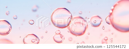 Multiple glossy and transparent bubbles of varying sizes are floating against a soft pink and blue gradient background, creating a serene and dreamy atmosphere with a scientific touch 125544172
