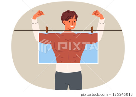 Man bodybuilder dreams of pumped up muscles and ripped abs, hiding behind photo with fake body 125545013