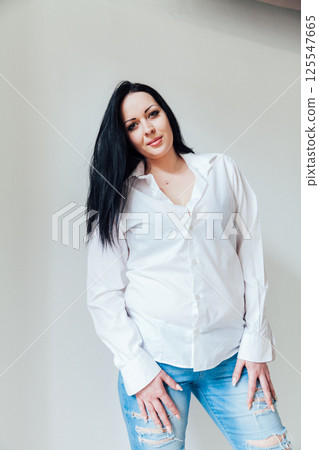 Fashion brunette woman in white shirt portrait on gray background 125547665