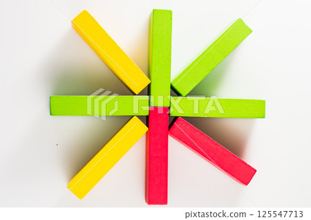 Wooden blocks are arranged on a flat surface in a random order. The multicolored elements look bright and attractive. 125547713