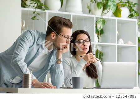 Man and Woman Working Together on Laptop Business Collaboration, Teamwork in Office 125547892