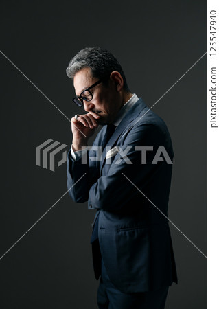 Businessman thinking sideways Businessman thinking sideways 125547940