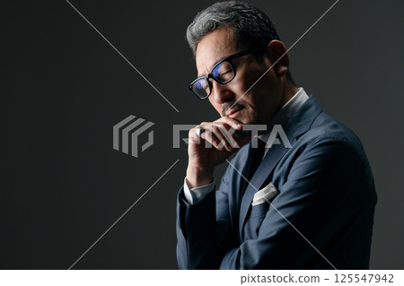 Businessman thinking sideways Businessman thinking sideways 125547942