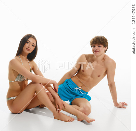 Beautiful young couple sitting casually with stylish swimwear in summer light Beautiful young couple sitting casually with stylish swimwear in summer light 125547988