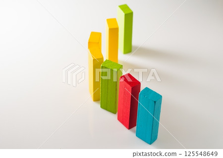 Developmental wooden blocks rest on a light background. The colorful pieces look bright and harmonious. Developmental wooden blocks rest on a light background. The colorful pieces look bright and harmonious. 125548649