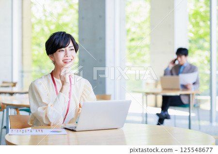 Businesswoman working on a computer in a cafe Businesswoman working on a computer in a cafe 125548677