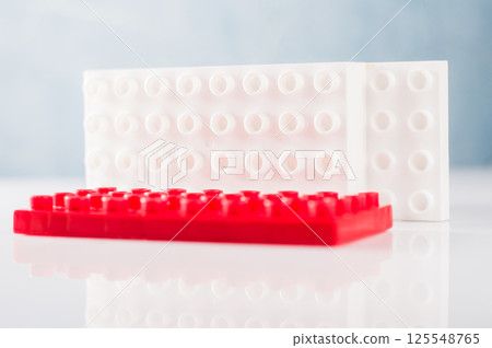 The children's plastic construction set displays a chaotic combination of elements. The colorful parts of the constructor form a dynamic structure.  125548765