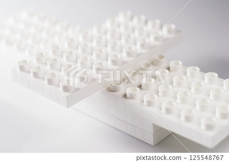 The plastic construction set for children consists of numerous colorful modules. The elements are connected without any specific order. The plastic construction set for children consists of numerous colorful modules. The elements are connected without any specific order. 125548767