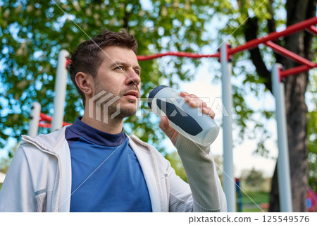 Man drinking water during outdoor workout Man drinking water during outdoor workout 125549576