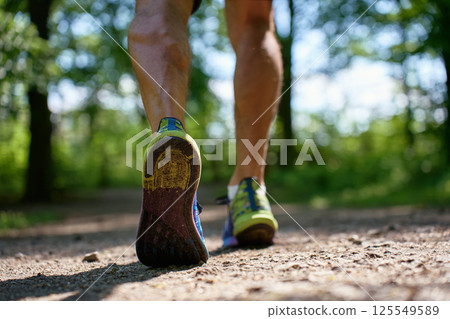 Runner shoes close-up on forest trail during outdoor workout 125549589