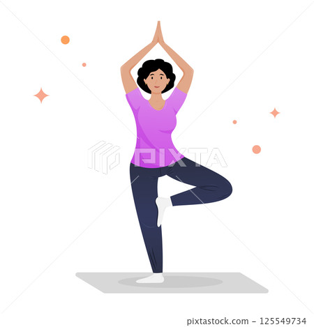 A woman demonstrates tree pose yoga, balancing gracefully on one leg. 125549734