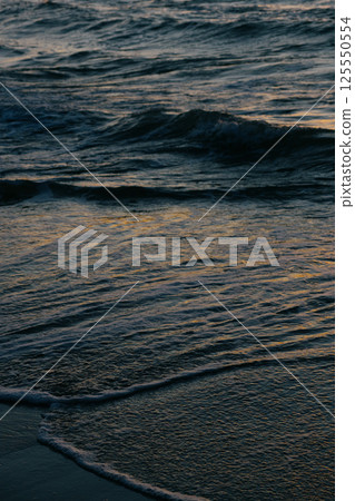 Ocean with waves, sunset sky is orange. water is choppy and waves are crashing on shore. Ocean with waves, sunset sky is orange. water is choppy and waves are crashing on shore. 125550554