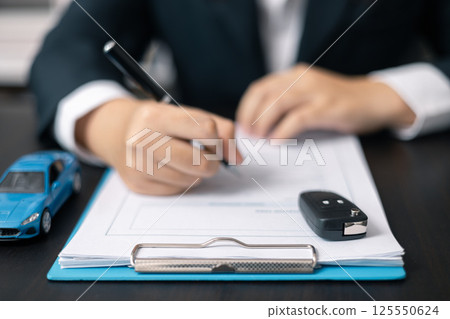 Dealership offered various finance options, including an auto loan or lease, making it easier to buy or rent a car from the company. Agent reviewed contract, finalizing insurance agreement. Dealership offered various finance options, including an auto loan or lease, making it easier to buy or rent a car from the company. Agent reviewed contract, finalizing insurance agreement. 125550624