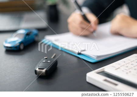 Dealership offered various finance options, including an auto loan or lease, making it easier to buy or rent a car from the company. Agent reviewed contract, finalizing insurance agreement. 125550627