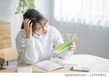 A woman looking at a passbook 125550631