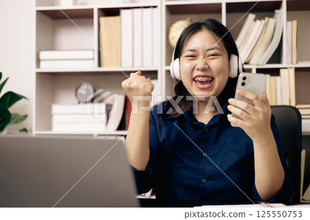 Online academy, student and woman conduct research on their laptops, people work on desktops in office. Young person utilizes technology and cyberspace for studying, preparing for university exam. 125550753