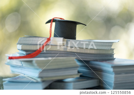 Graduation from college with university degree in finance marked successful culmination of education, envisioning value of each coin invested. coin, college, education, graduation, hat, school. Graduation from college with university degree in finance marked successful culmination of education, envisioning value of each coin invested. coin, college, education, graduation, hat, school. 125550856