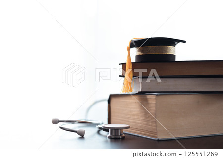 Surrounded by medical books and equipped with stethoscope, embodying years of education and dedication to providing quality health care. Concept of studying medical education. doctor, medicine. 125551269