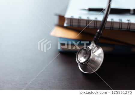 Surrounded by medical books and equipped with stethoscope, embodying years of education and dedication to providing quality health care. Concept of studying medical education. doctor, medicine. Surrounded by medical books and equipped with stethoscope, embodying years of education and dedication to providing quality health care. Concept of studying medical education. doctor, medicine. 125551270