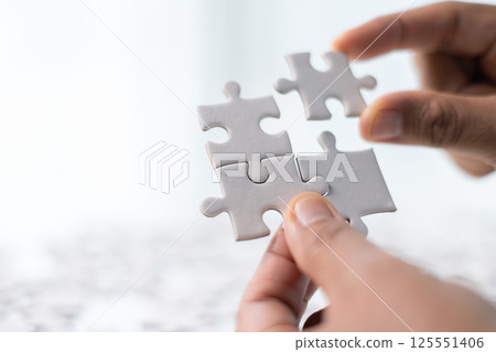 Team with piece of jigsaw puzzle as critical component of business strategy, understanding teamwork and collaboration were essential for achieving success and realizing concept of well-executed plan. 125551406