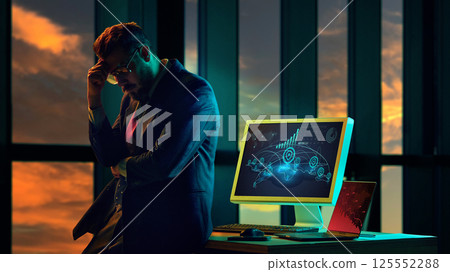 Stressed businessman standing next to computer showing global economic collapse, worldwide meltdown, market crash. Stressed businessman standing next to computer showing global economic collapse, worldwide meltdown, market crash. 125552288