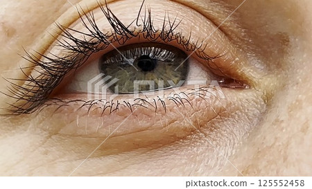 Focus on right green eye of attractive girl blinking and looking into camera. Portrait of upset female face. Sorrowful facial expression of young woman. Unhappy sight of beautiful lady. Close up Focus on right green eye of attractive girl blinking and looking into camera. Portrait of upset female face. Sorrowful facial expression of young woman. Unhappy sight of beautiful lady. Close up 125552458