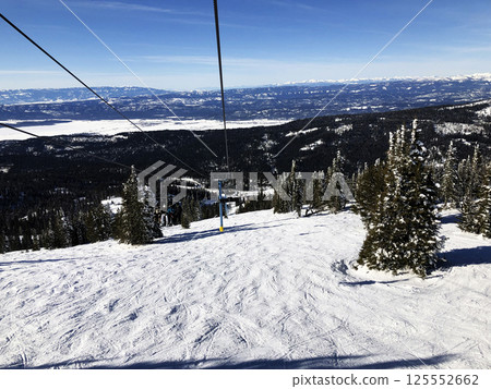 Skiers on ski lift at Brundage Mountain ski resort at the top of slope. Skiers on ski lift at Brundage Mountain ski resort at the top of slope. 125552662