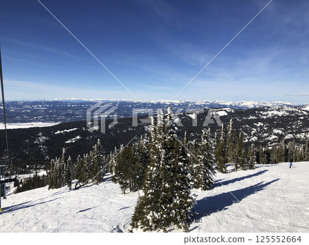 Panoramic view of snow-covered mountain ranges from the ski lift at Brundage Mountain ski resort. Panoramic view of snow-covered mountain ranges from the ski lift at Brundage Mountain ski resort. 125552664