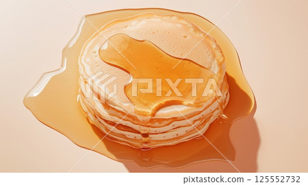 Top view of a stack of pancakes drizzled with honey on an orange background 125552732