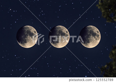 Three full moons shining brightly in a starry night sky 125552789