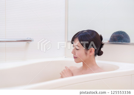 A middle-aged woman relaxing in the bath at home 125553336