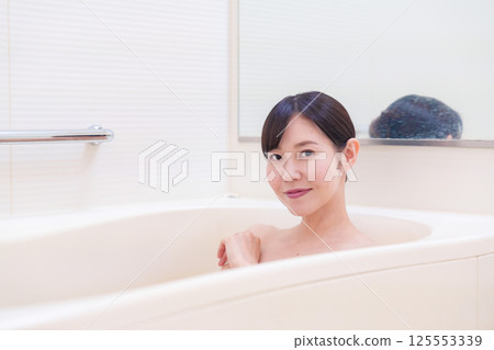 A middle-aged woman relaxing in the bath at home A middle-aged woman relaxing in the bath at home 125553339