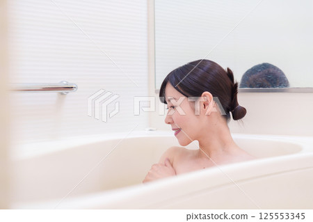 一位中年婦女在家洗澡放鬆 一位中年婦女在家洗澡放鬆 125553345