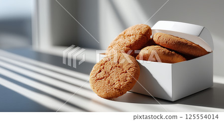 Minimalist cookie packaging box with gingersnap cookies table, sunlight, cozy and inviting mood 125554014