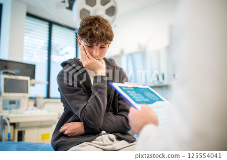 Doctor and teenage patient filling out mental health evaluation form. Doctor and teenage patient filling out mental health evaluation form. 125554041