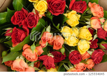 Full frame of beautifully decorated bouquet of red, yellow and orange roses. 125554045