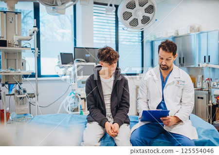 Empathetic doctor supporting teenage patient during health consultation. 125554046